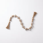 Cargar imagen en el visor de la Galería, Cuentas decorativas Mala Sina de madera con borlas para mesa y repisa sobre fondo blanco.