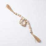 Cargar imagen en el visor de la Galería, Guirnalda de cuentas decorativas Mala Tashi de MDF 77cm con borlas sobre fondo blanco.