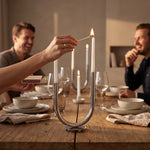 Cargar imagen en el visor de la Galería, Mano encendiendo el candelabro portavelas en forma de U decorativo para comedor 25x35cm en la mesa.