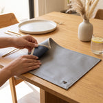 Cargar imagen en el visor de la Galería, Mantel rectangular doble vista gris plata y azul marino de 34x47 cm sobre una mesa de comedor.