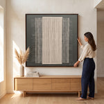 Cargar imagen en el visor de la Galería, Mujer colgando el Cuadro Abstracto Entramados I Acrílico Marco Madera Nogal 120 x 120 en una sala luminosa.