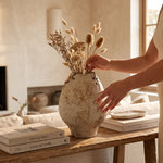 Cargar imagen en el visor de la Galería, Jarrón Ligna blanco texturizado con detalles marrones de 31.5 cm con flores secas en mesa de madera.