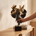 Cargar imagen en el visor de la Galería, Figura decorativa Sirel de poliresina y metal negro con dorado sobre un mueble de madera