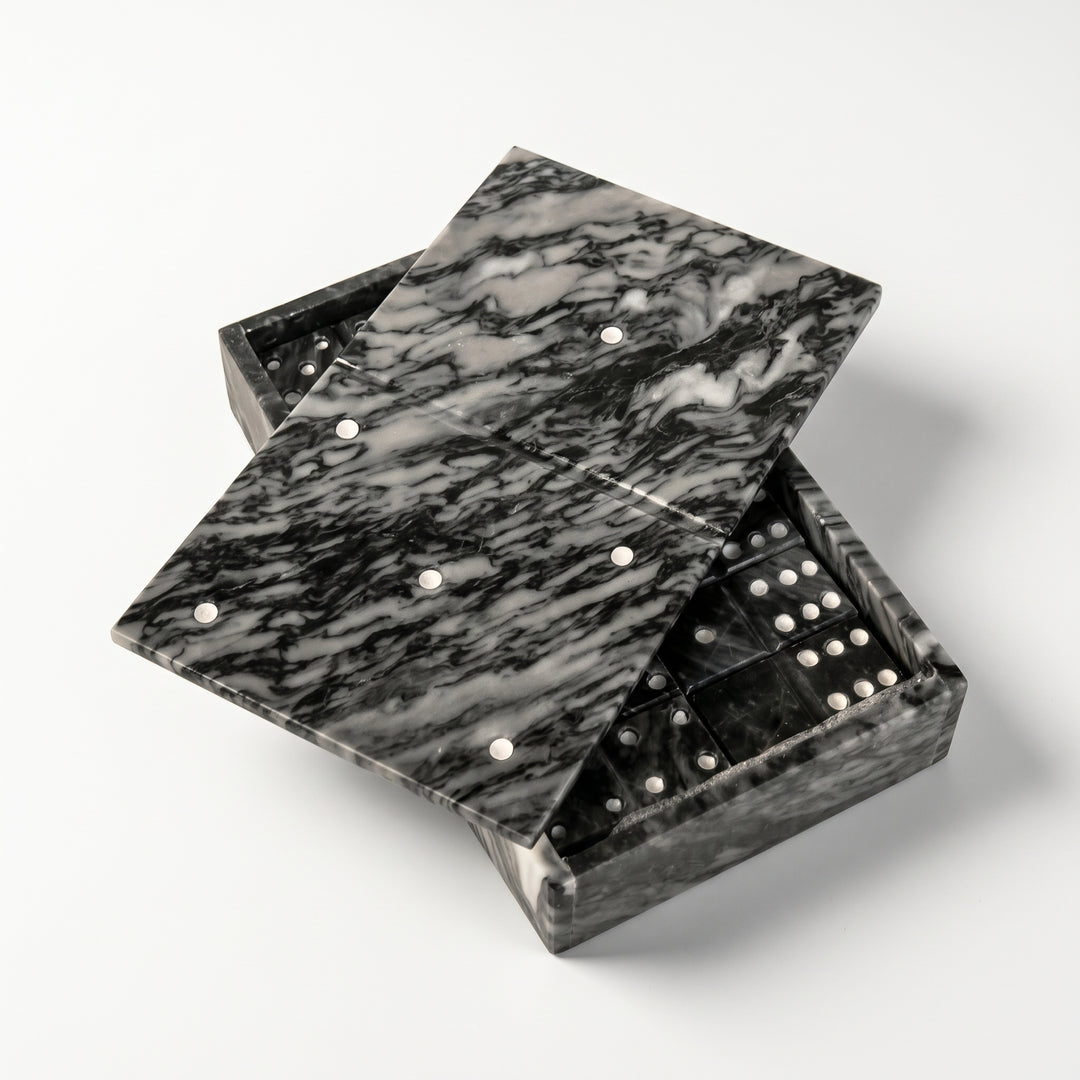 Dominó de mármol negro veteado en su caja decorativa entreabierta con fichas.