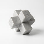 Cargar imagen en el visor de la Galería, Escultura decorativa Matatena Nudo de mármol natural con bloques entrelazados sobre fondo blanco.