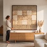 Cargar imagen en el visor de la Galería, Mujer junto a cuadro telar arte texturizado alto relieve 140x140 marco nogal sobre mueble de madera.