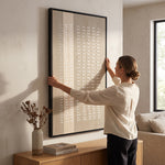 Cargar imagen en el visor de la Galería, Mujer colgando el cuadro decorativo Sabi acrílico alto relieve de 90x150 cm en una moderna sala luminosa.