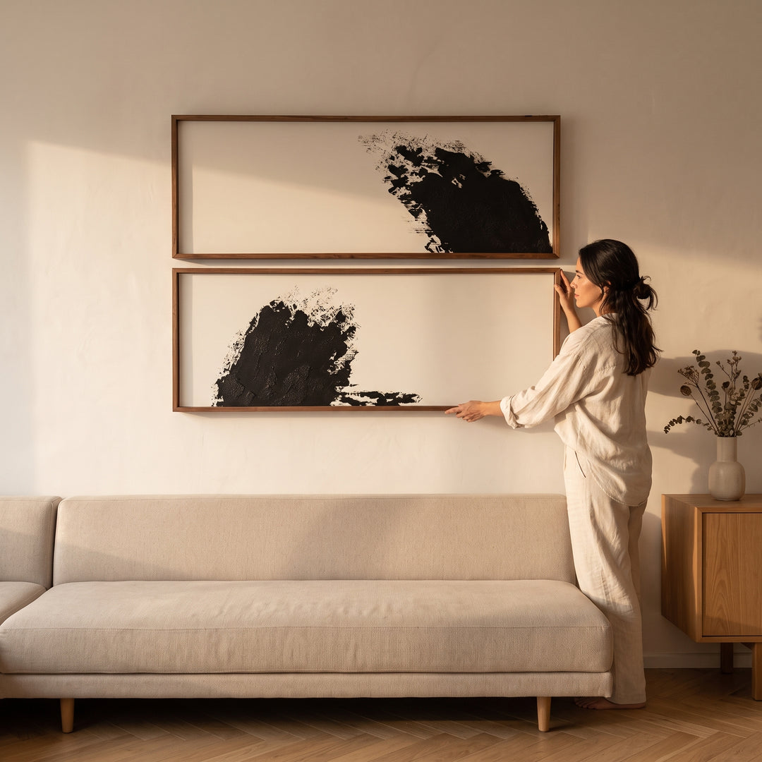 Mujer ajustando los cuadros decorativos abstractos Urban en madera sólida juego de 2 en la sala.