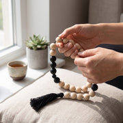 Manos sosteniendo el Mala Farzin, collar de cuentas para meditación y mindfulness.