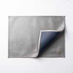 Cargar imagen en el visor de la Galería, Mantel rectangular doble vista gris plata y azul marino 34x47 cm mostrando su diseño reversible.