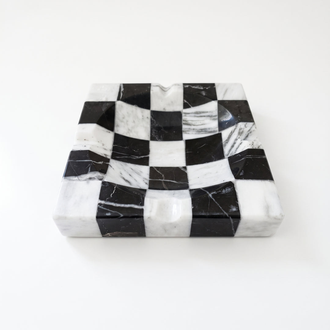 Cenicero de mármol cuadrado con diseño de ajedrez en blanco y negro.