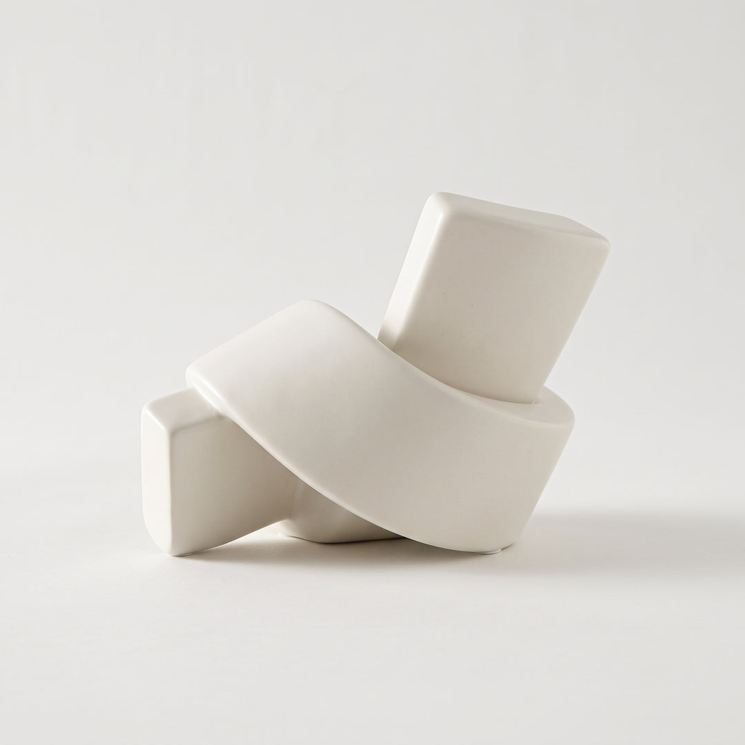 Accesorio decorativo de cerámica nudo blanco de diseño moderno y acabado mate sobre fondo neutro.