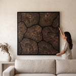 Cargar imagen en el visor de la Galería, Mujer colocando el cuadro flor de loto grande 120x120 cm decorativo sobre un sofá beige.