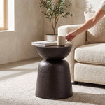 Cargar imagen en el visor de la Galería, Mesa auxiliar Gladis compacta para sala o dormitorio en tono oscuro junto a un sillón beige con taza y libro.