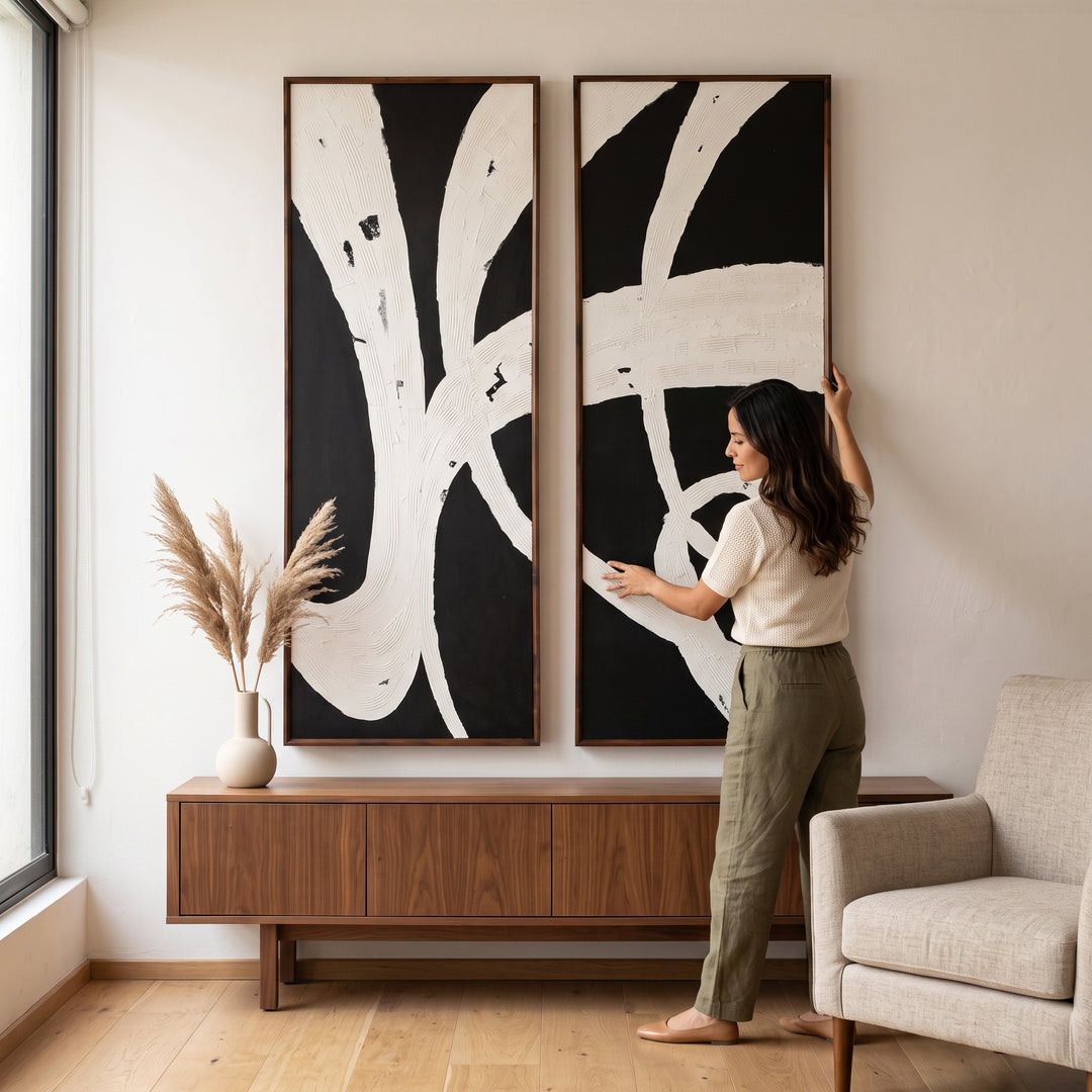 Set 2 cuadros decorativos Abismo con moldura nogal y arte abstracto en blanco y negro en una sala moderna.