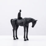 Cargar imagen en el visor de la Galería, Escultura de caballo y hombre decorativa de resina para interiores en tono negro texturizado.
