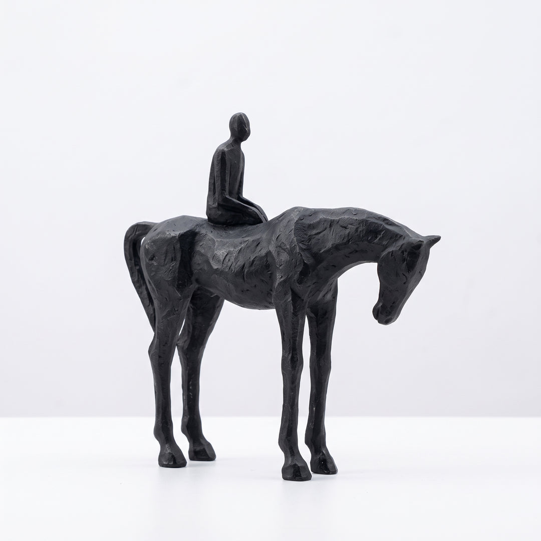 Escultura de caballo y hombre decorativa de resina para interiores en tono negro texturizado.