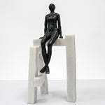Cargar imagen en el visor de la Galería, Escultura Hombre Sentado en Base I de Resina negra sobre estructura geométrica blanca.