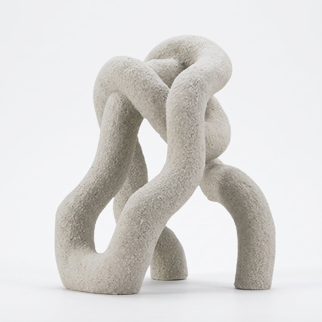 Accesorio Vania, escultura decorativa de poliresina blanca con acabado rugoso y formas entrelazadas.