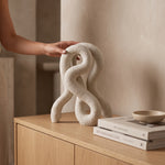 Cargar imagen en el visor de la Galería, Accesorio decorativo Nerel de poliresina blanca 36 cm sobre mueble de madera junto a libros.